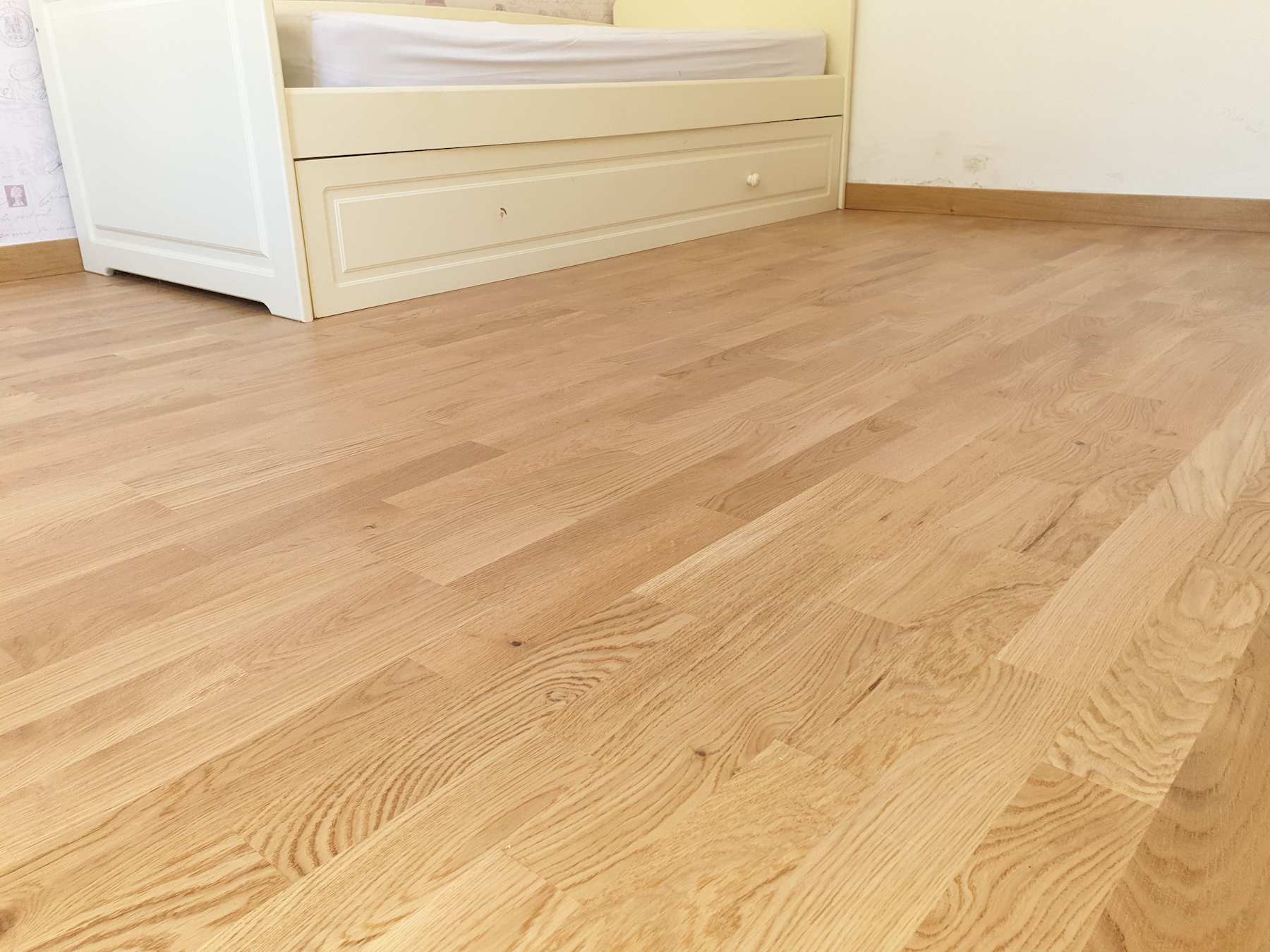 Suelo sintético de resistencia ac 5 de estilo natural instalado en el dormitorio de un piso de 80m2